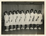Nine female nurses holding diplomas by Lonnie W. Fleming Sr.