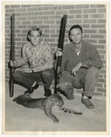 Two men showing off a wildcat/bobcat they killed with their shotguns in hand by Lonnie W. Fleming Sr.