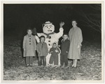 Four children with their mom at right, showing off a snowman that is dressed up by Lonnie W. Fleming Sr.
