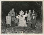 Six children standing with three adults near a snowman by Lonnie W. Fleming Sr.
