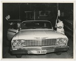 A housekeeper and members of the wedding party at the groom's car by Lonnie W. Fleming Sr.