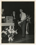 Men on a stage with flowers in front of a microphone by Lonnie W. Fleming Sr.