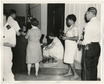At a reception in Conway City Hall for foreign military delegates, lady getting Cokes from a crate by Lonnie W. Fleming Sr.