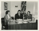 Three people sitting together at a desk by Lonnie W. Fleming Sr.
