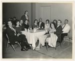 Party attendees in dress clothes sitting around tables by Lonnie W. Fleming Sr.