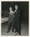 Two men in suits holding a small object in the air by Lonnie W. Fleming Sr.