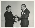 An older man handing a check to a younger man by Lonnie W. Fleming Sr.