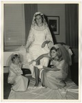 The bride is having her garter removed by a bridesmaid and the flower girl by Lonnie W. Fleming Sr.