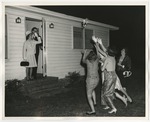 Photo of the bride throwing her garter from the front steps to females waiting outside of a home by Lonnie W. Fleming Sr.
