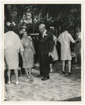 Photo of a woman (with her shoes off) talking to a man in a black suit by Lonnie W. Fleming Sr.