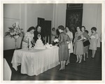 Photo of the wedding cake being cut by two ladies in the First United Methodist Church Fellowship Hall by Lonnie W. Fleming Sr.