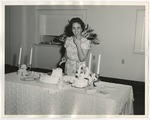 Photo of a lady cutting the wedding cake and licking her finger by Lonnie W. Fleming Sr.