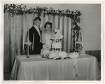 Photo of the bride and groom cutting their three layered wedding cake by Lonnie W. Fleming Sr.