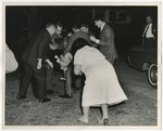 A housekeeper is trying to help the groom by prodding young men with her mop by Lonnie W. Fleming Sr.