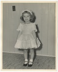 Photo of a young girl wearing a white dress, black dress shoes, and a white bow in her hair by Lonnie W. Fleming Sr.