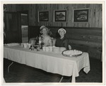 Photo of two elderly ladies sitting at a refreshment table by Lonnie W. Fleming Sr.