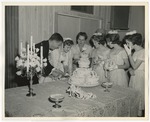 Photo of the bride and groom cutting the wedding cake with bridesmaids looking on by Lonnie W. Fleming Sr.
