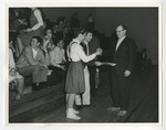 Photo of a male and female student standing on the Conway High School gymnasium floor with an older male by Lonnie W. Fleming Sr.