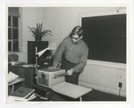 Photo of a male rolling the transparency film on the overhead projector by Lonnie W. Fleming Sr.