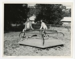 Photo of two girls playing on a merry-go-round by Lonnie W. Fleming Sr.