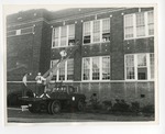 A photo of a male and female student climbing up a ladder by Lonnie W. Fleming Sr.