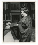 A posed photo of a girl in graduation robes accepting her diploma in front of Conway High School by Lonnie W. Fleming Sr.