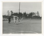 A photo of a baseball player crossing home base during a baseball game The umpire is watching by Lonnie W. Fleming Sr.