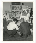 Two men in dress attire gathering signs and posters in an office at Conway High School by Lonnie W. Fleming Sr.