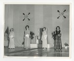 A photo of four girls on-stage holding numbered fan-shaped pieces of paper by Lonnie W. Fleming Sr.