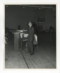 A photo of a man singing to an audience in the Conway High School gymnasium by Lonnie W. Fleming Sr.