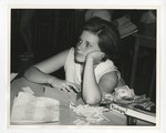 A photo of a girl resting her head on her hand with a stack of dollar bills next to her by Lonnie W. Fleming Sr.