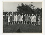 A photo of a group of girls lined up on a lawn and wearing hats by Lonnie W. Fleming Sr.