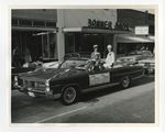 A photo of two girls in outerwear on top of a Pontiac by Lonnie W. Fleming Sr.