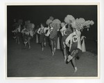 A photo of a row of cheerleaders cheering on a team in the sand by Lonnie W. Fleming Sr.