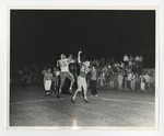 A photo of two opposing football players trying to catch a football during a game by Lonnie W. Fleming Sr.