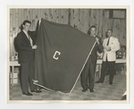 A photo of a male student and a man holding up a blanket with a "C" on it by Lonnie W. Fleming Sr.
