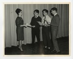 A photo of three young male Conway High School students accepting certificates from a woman by Lonnie W. Fleming Sr.