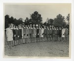 A photo of a row of women in hats and coats posing on a lawn by Lonnie W. Fleming Sr.