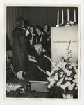 A photo of a blonde girl in a gown sitting on the stage floor of a National Honor Society induction ceremony by Lonnie W. Fleming Sr.