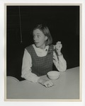 A photo of a girl looking at a spider while pretending to eat cereal by Lonnie W. Fleming Sr.