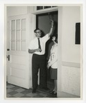 A photo of a man showing a girl a piece of mistletoe hanging in a doorway by Lonnie W. Fleming Sr.