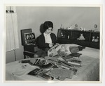 A photo of a girl cutting magazines and newspapers on her bed by Lonnie W. Fleming Sr.