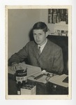 A photo of a gentleman sitting at his desk and wearing a suit by Lonnie W. Fleming Sr.