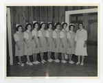 7 young nurses and an elder nurse on the stage left posing for photo by Lonnie W. Fleming Sr.