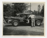 Race car driver standing by race car by Lonnie W. Fleming Sr.