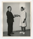 Suited gentleman presenting an award bowl to a female nurse by Lonnie W. Fleming Sr.