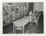 Two women sitting and talking in a library by Lonnie W. Fleming Sr.