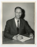 An African-American gentleman posing for a picture while sitting with a pen and paper in his hand by Lonnie W. Fleming Sr.