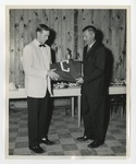 Bob Clark and student holding a piece of cloth with a C on it by Lonnie W. Fleming Sr.