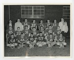 A football team group picture in front of a brick building by Lonnie W. Fleming Sr.